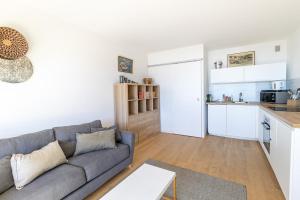 a living room with a couch and a kitchen at Face a la mer Cassis in Cassis
