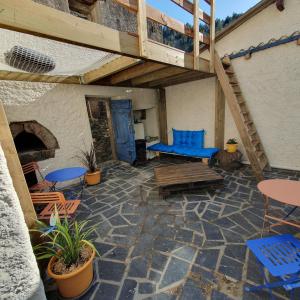 a patio with blue chairs and tables and a fireplace at Gîte à Florac "Les Rêves Bleus" in La Salle-Prunet