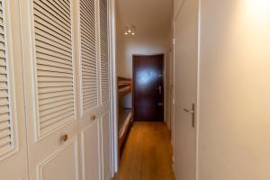 a hallway with wooden floors and a door with shutters at Face a la mer Cassis in Cassis