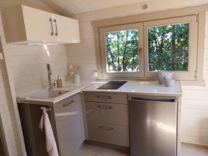 a small kitchen with a sink and a window at Chalet cosy avec terrasse & hamac, calme, proche plage, parking, NC Properties in Grimaud