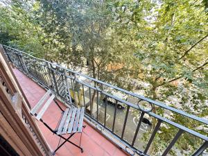 a chair sitting on a balcony with a railing at Rooms Diputacion in Barcelona