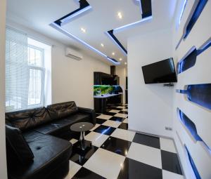Розкішні люкс апартаменти біля Майдану في كييف: غرفة معيشة مع أريكة وتلفزيون