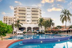 a hotel with a large swimming pool and a building at Condominios Torre Continental Ixtapa in Ixtapa