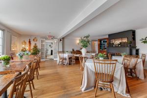 a dining room with wooden tables and chairs at Red Clover Inn in Mendon