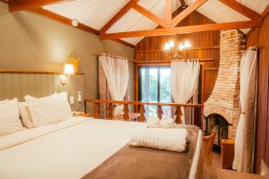 a bedroom with a bed and a fireplace at Pousada das Pedras in Monte Verde