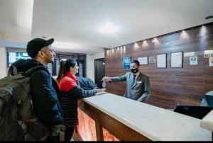a group of people standing around a counter at Hotel Sandhya in Kasol