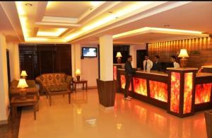 a hotel lobby with people standing at a bar at Hotel Sandhya in Kasol