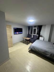 a bedroom with a bed and a couch and a tv at Marin konaklama in Pendik