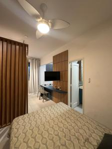 a bedroom with a bed and a desk and a ceiling fan at House Brigadeiro in Juiz de Fora
