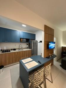 a kitchen with blue cabinets and a table and chairs at House Brigadeiro in Juiz de Fora