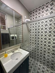 a bathroom with a sink and a shower at House Brigadeiro in Juiz de Fora