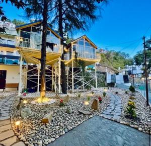 a house with a tree in front of a building at Treehouse by the lake in Bhīm Tāl
