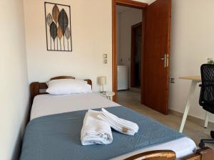 a bedroom with a bed with two towels on it at Leka Village Our Hidden Gem in Léka