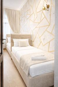 a bedroom with a white bed with a geometric wall at Old Yerevan by IGIT in Yerevan