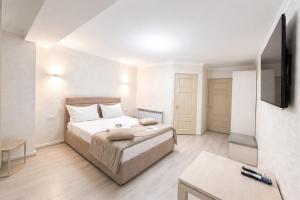 a bedroom with a bed and a flat screen tv at Old Yerevan by IGIT in Yerevan