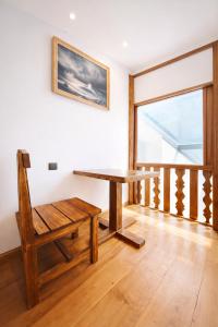 a wooden table and a bench in a room with a window at Old Yerevan by IGIT in Yerevan