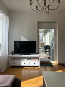 Ein Wohnzimmer mit einem Flachbildfernseher auf einem weißen Entertainment-Center in der Unterkunft Kattby in Hammarland