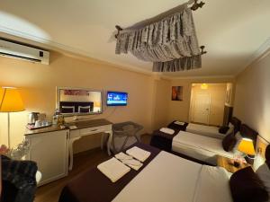 ein Hotelzimmer mit zwei Betten und einem Schreibtisch in der Unterkunft SRF Boutique Hotel in Eskisehir