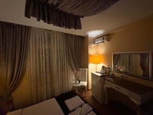ein Hotelzimmer mit Bett, Schreibtisch und Spiegel in der Unterkunft SRF Boutique Hotel in Eskisehir + 4 Fotos