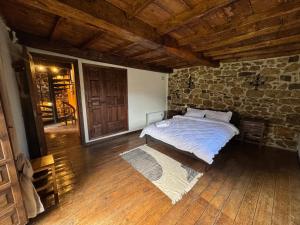 a bedroom with a bed and a brick wall at Casa de Aldea EL Fusu in Taranes