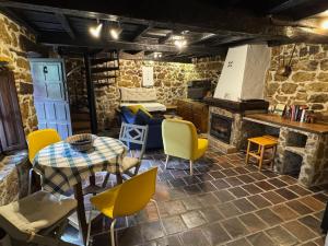 a living room with a table and yellow chairs at Casa de Aldea EL Fusu in Taranes