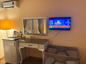 ein Zimmer mit einem Schreibtisch und einem Fernseher an der Wand in der Unterkunft SRF Boutique Hotel in Eskisehir