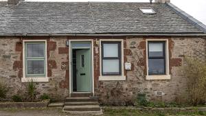 a brick house with a green door and windows at The Stay at Straad in Island of Bute