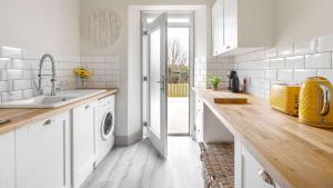 a kitchen with a sink and a washing machine at The Stay at Straad in Island of Bute