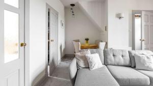 a living room with a gray couch and a table at The Stay at Straad in Island of Bute