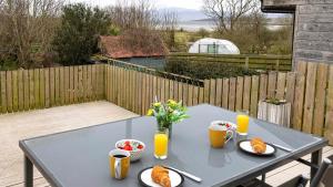 a blue table with plates of food and orange juice at The Stay at Straad in Island of Bute +7 photos