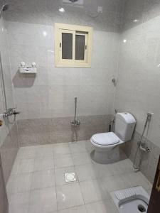 a bathroom with a toilet and a window at استديو كلاود in Al Baha