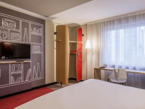 a bedroom with a bed and a surfboard on a wall at Ibis Poznan Centrum in Poznań