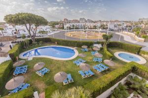 an overhead view of a pool with chairs and umbrellas at BLUESEA El Cortijo in Matalascañas