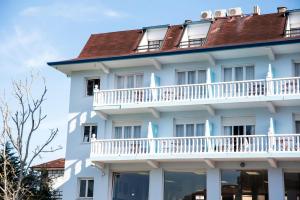 ein weißes Gebäude mit einem weißen Balkon in der Unterkunft BLUESEA Noja in Noja