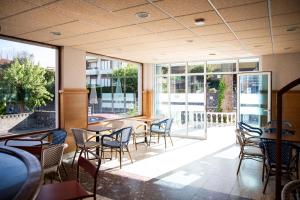 ein Restaurant mit Tischen, Stühlen und Fenstern in der Unterkunft BLUESEA Noja in Noja + 54 Fotos