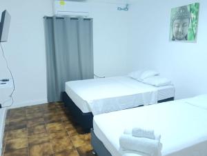 two beds in a room with white walls at Hostal Dream House in San Andrés