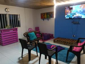 a room with chairs and a tv on a wall at Hostal Dream House in San Andrés