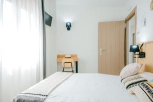 a bedroom with a white bed and a desk at BLUESEA Faro Cullera in Cullera