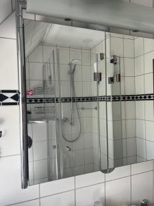 a glass shower in a white tiled bathroom at Wattlöwe ruhige Ferienwohnung mit Terrasse nahe Eider & Deich in Tönning +46 photos