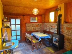 a kitchen with a table and a stove at Chaloupka u Vejvodů in Skřípov