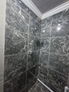 a bathroom with a black tiled shower with at Mams Cozy Guest house in Seshego +23 photos