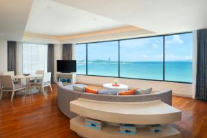 a living room with a couch and a view of the ocean at Amari Pattaya in Pattaya