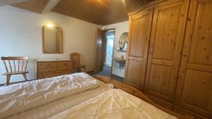 a bedroom with a bed and a dresser and a chair at Upkammer im Park in Werdum +1 photo