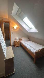 a attic room with a bed and a skylight at Upkammer im Park in Werdum
