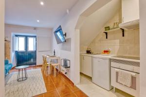 a kitchen with white cabinets and a table and chairs at Bairro Alto Cozy apartment in Lisbon