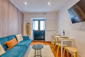 a living room with a blue couch and a table at Bairro Alto Cozy apartment in Lisbon