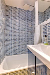 a bathroom with a white tub and a sink at Bairro Alto Cozy apartment in Lisbon