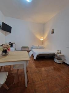 a white room with a bed and a table at Charming Home with Private Patio near Swiss Border and Transport - Daisy, Loggiadeifiori in Como
