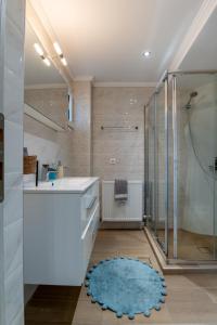 a bathroom with a shower and a blue rug at Maleme Maisonette in Maleme +40 photos