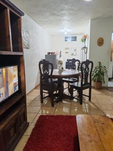 jadalnia ze stołem, krzesłami i telewizorem w obiekcie Apartment 2 w mieście Santa María Tonantzintla